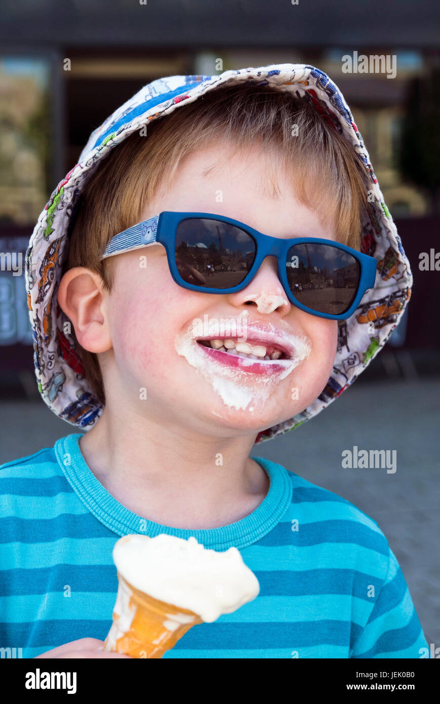 Young boy wearing sunglasses and eating ice cream Stock Photo