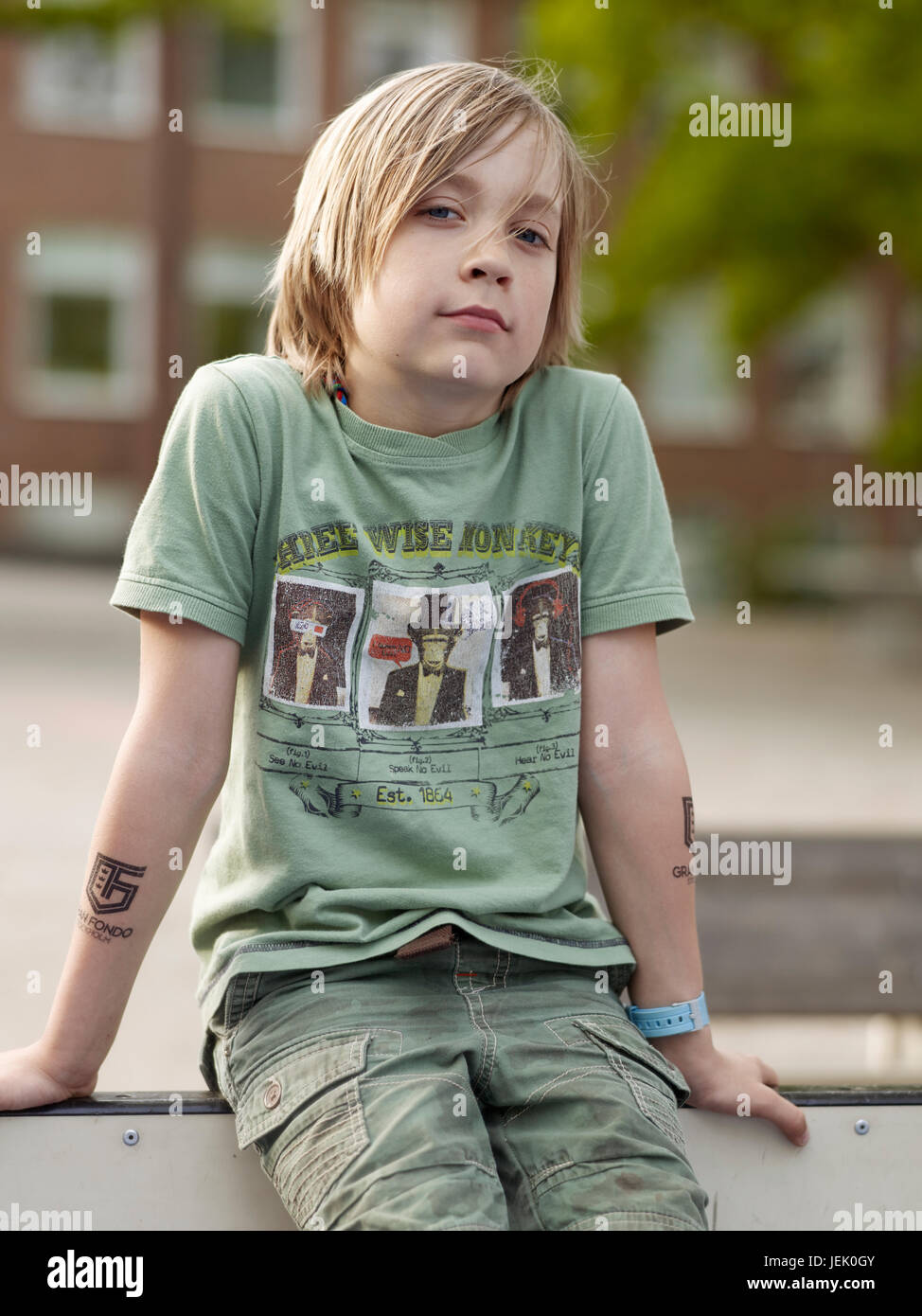 Boy sitting and looking at camera Stock Photo - Alamy