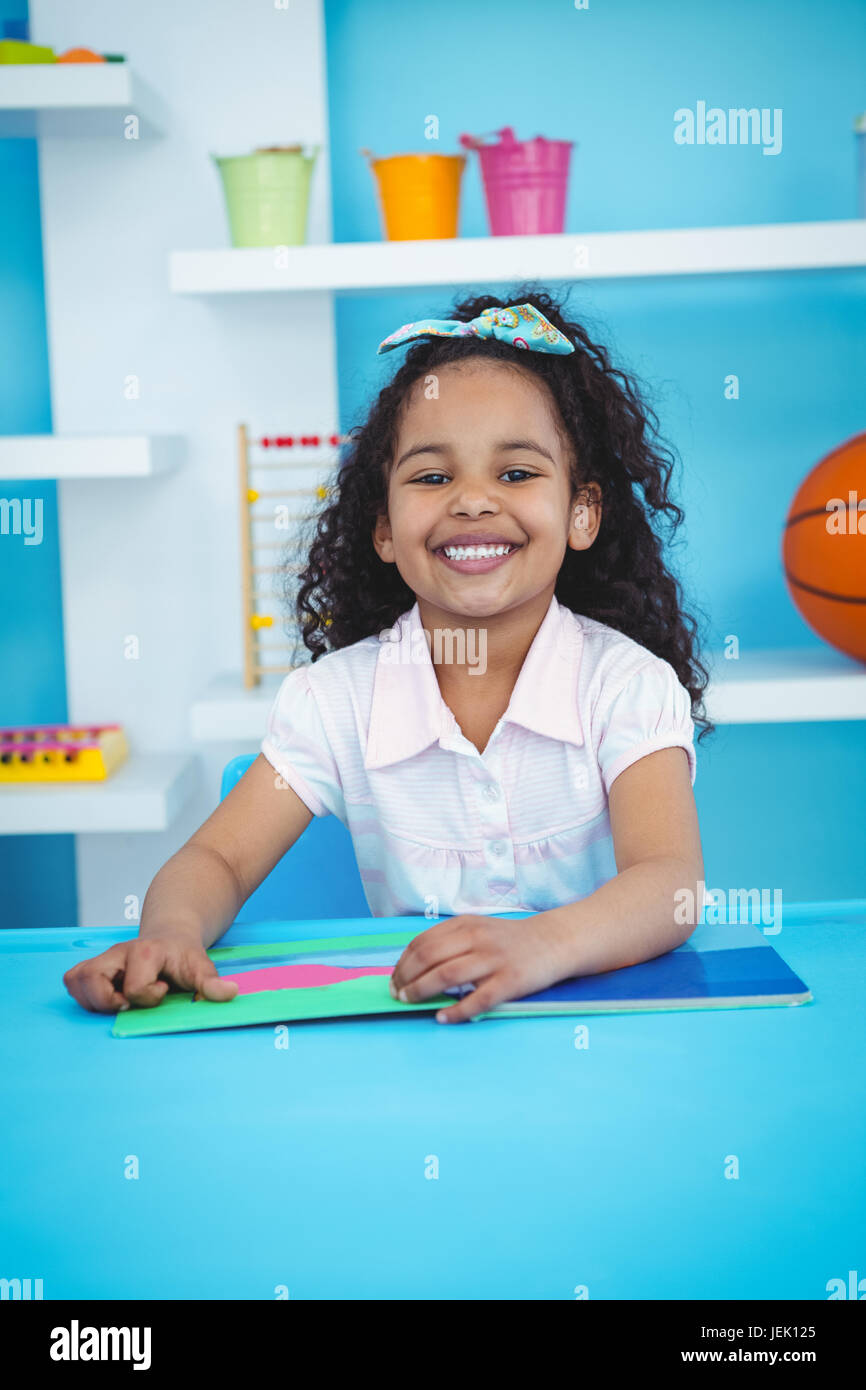 Cute girl with a book smiling at camera Stock Photo - Alamy