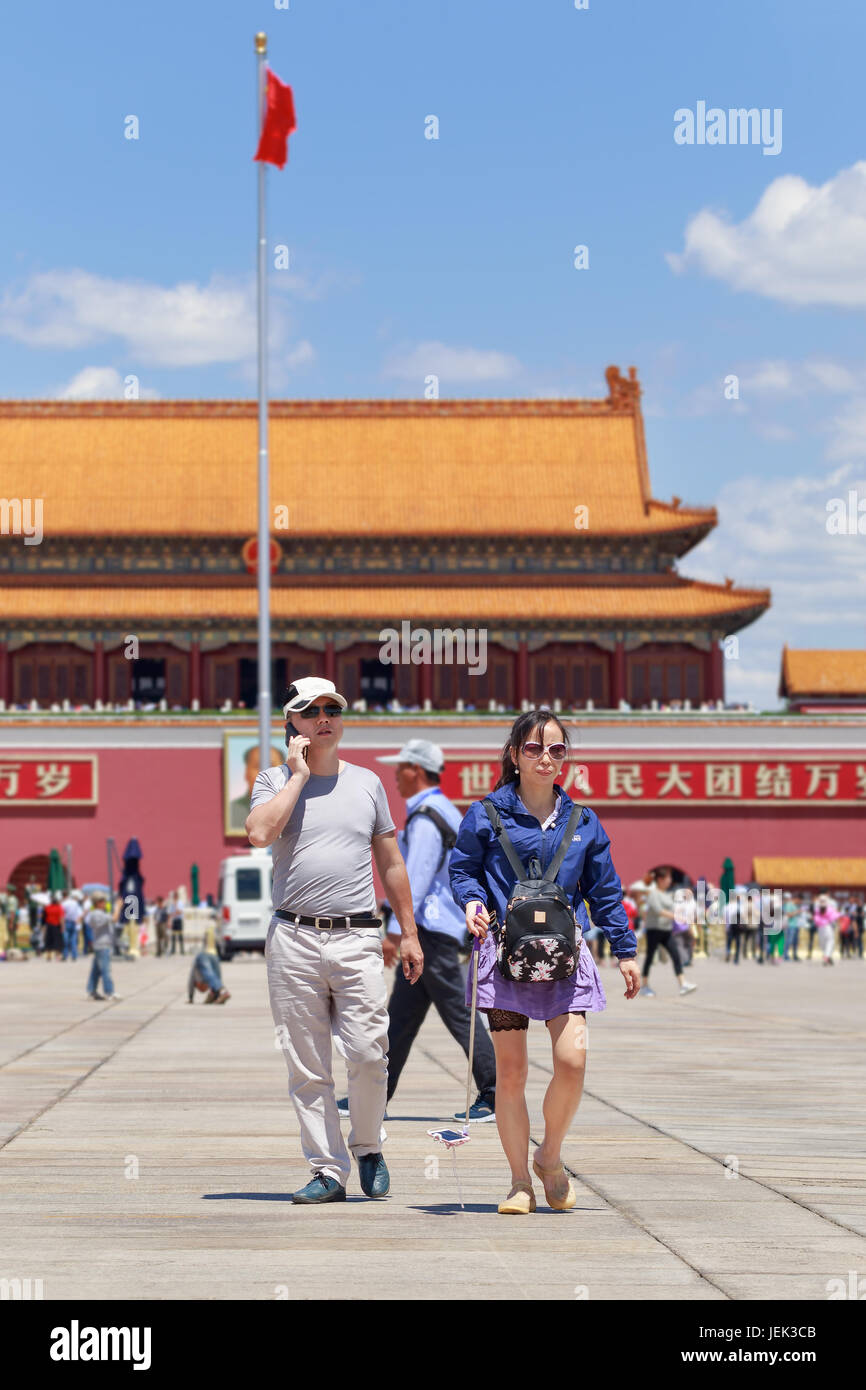 Couple walks at Tiananmen Square. With 440,500 m2 it is one of the world's largest squares and has great cultural significance for China. Stock Photo
