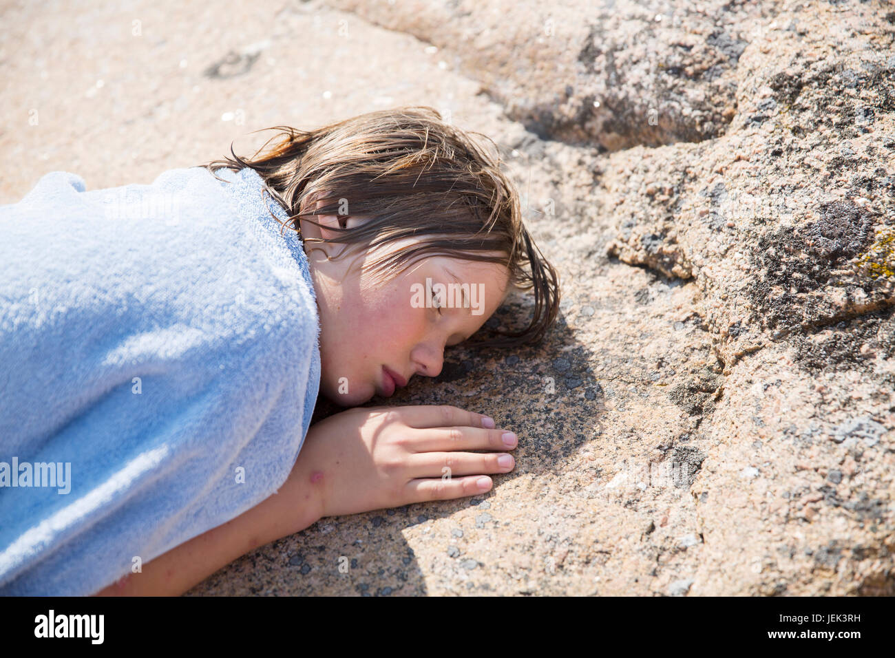 Boy covered with blanket sleeping on rock Stock Photo Alamy