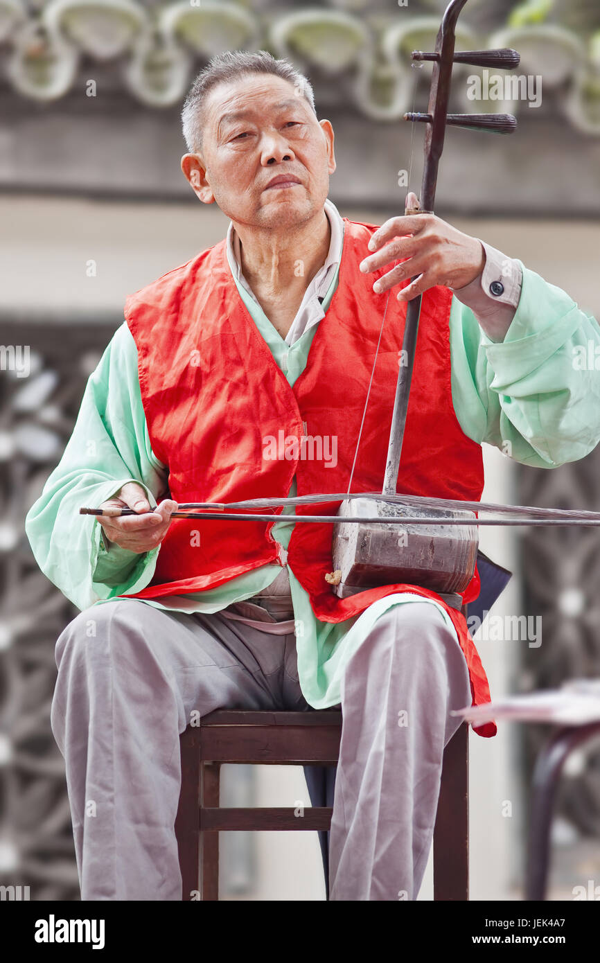 BEIJING-SEPT. 29, 2010. Old man plays an erhu, two-stringed bowed fiddle. The Erhu is an ancient Asian instrument, brought to China during Han dynasty Stock Photo