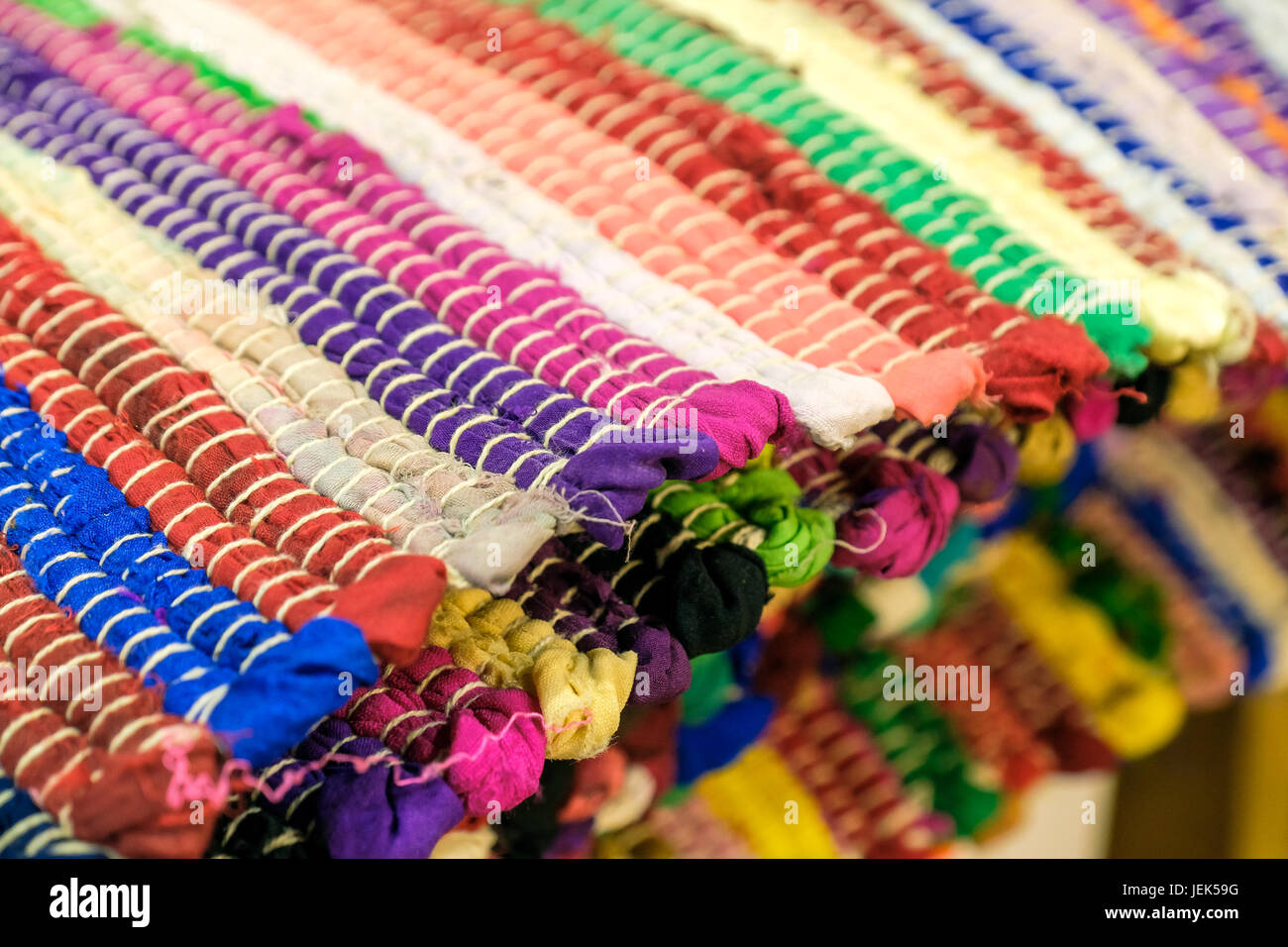 Colourful handmade rugs piled up on display at central market, South
