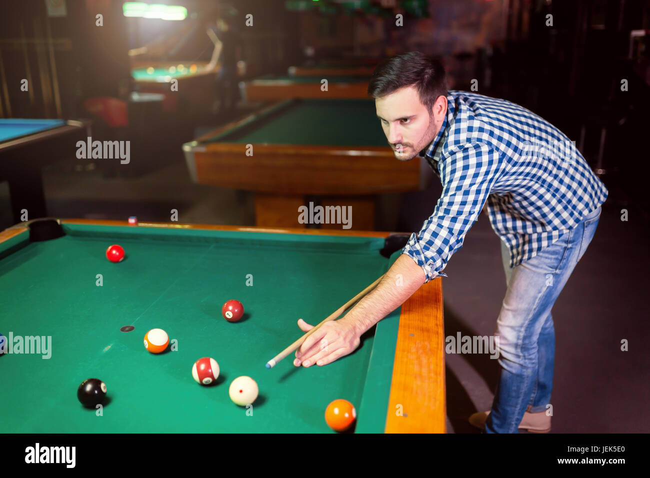 Hansome man playing pool in bar alone aiming Stock Photo