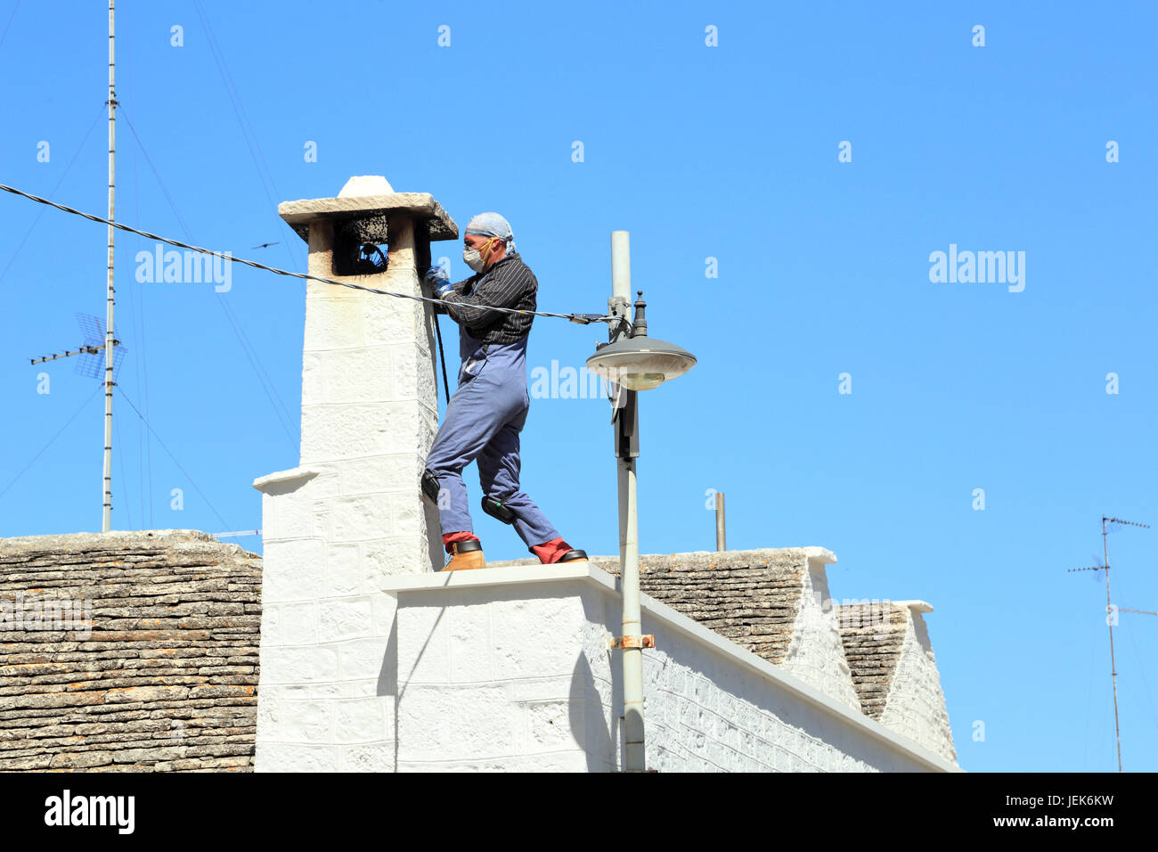 Chimney sweeper at trulli house, Italy Stock Photo