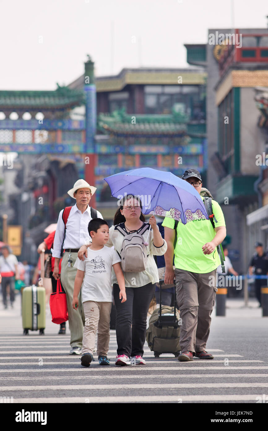 BEIJING-JUNE 9, 2015. Fat Chinese family with umbrella. China’s getting fatter, it’s weighing down the future of its children. It has 46 million obese. Stock Photo