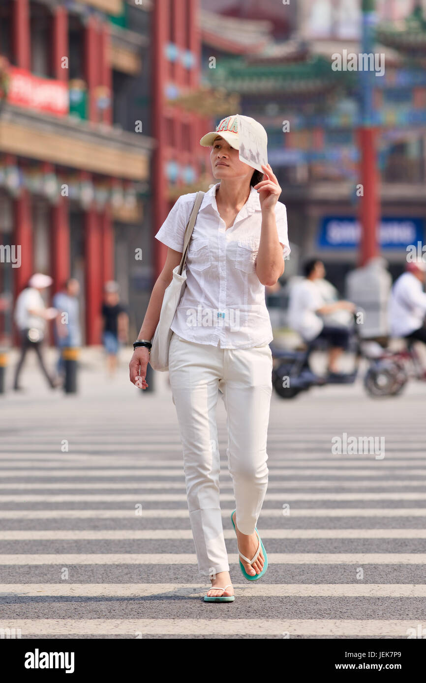 BEIJING-JUNE 9, 2015. Woman protects her face against a strong sun. Since ancient times a pale skin is an absolute Chinese beauty ideal. Stock Photo