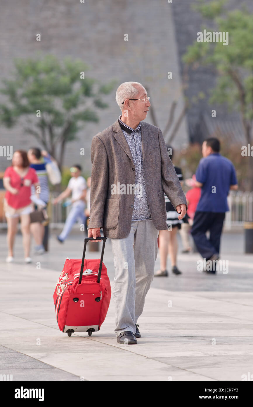 BEIJING-JUNE 9, 2015. Senior with suitcase. Elderly population (60 or older) in China is 128 million, one in every ten people, the world’s largest. Stock Photo