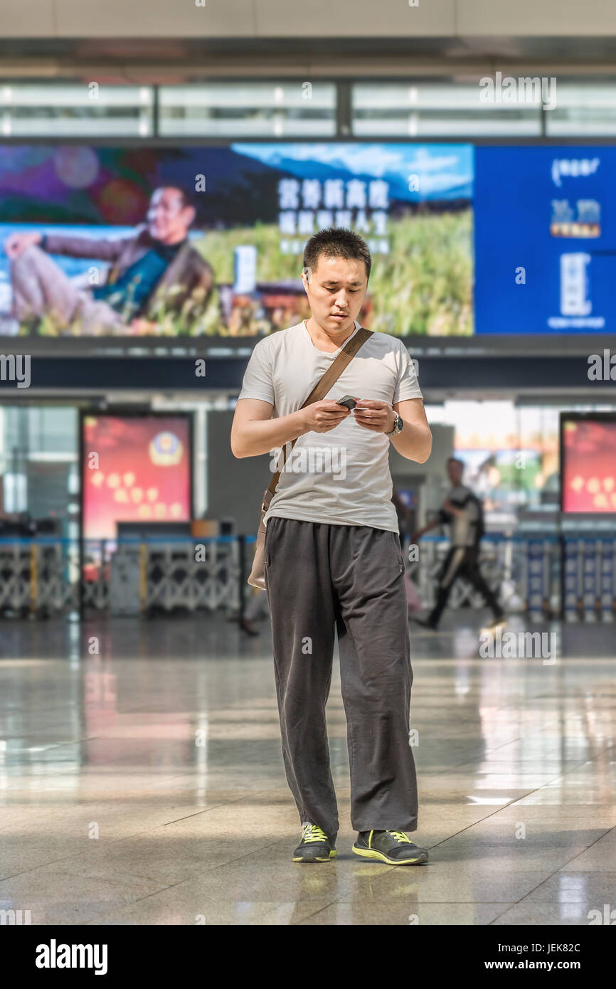 BEIJING-MAY 21, 2016. Fashionable young man at Beijing Railway Station South, the city's largest station and one of Asia’s biggest. Stock Photo