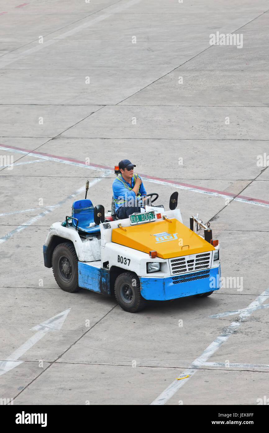 BEIJING-MAY 23. 2014. Nissan tow tractor for dolly transport on Beijing Airport. Speed, efficiency, and accuracy are essential in ground handling. Stock Photo