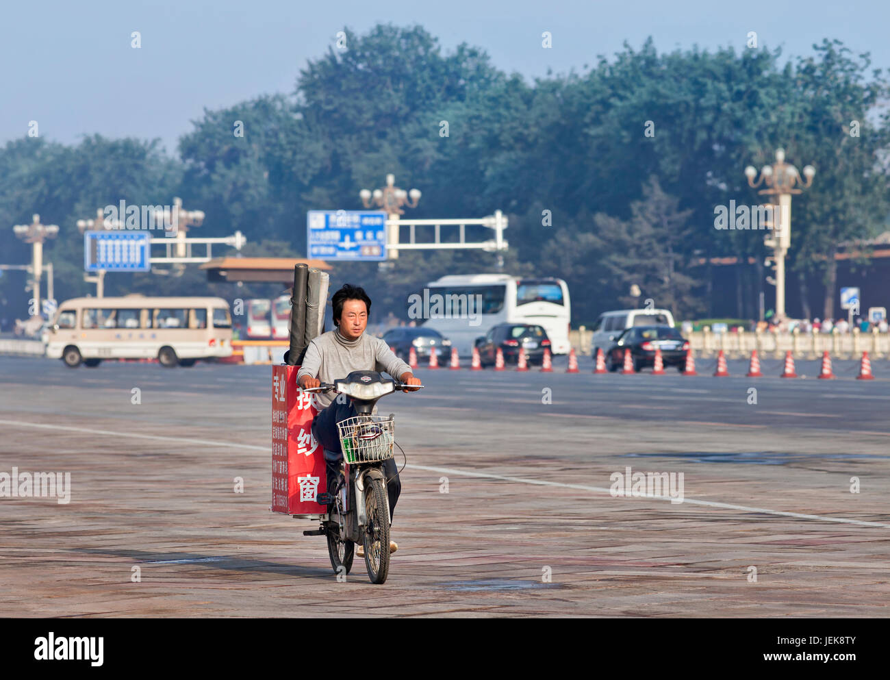 BEIJING-JUNE 1, 2013. Worker transports gauze rolls on his electric bike in the early morning. China has currently 150 million electric-bikes. Stock Photo