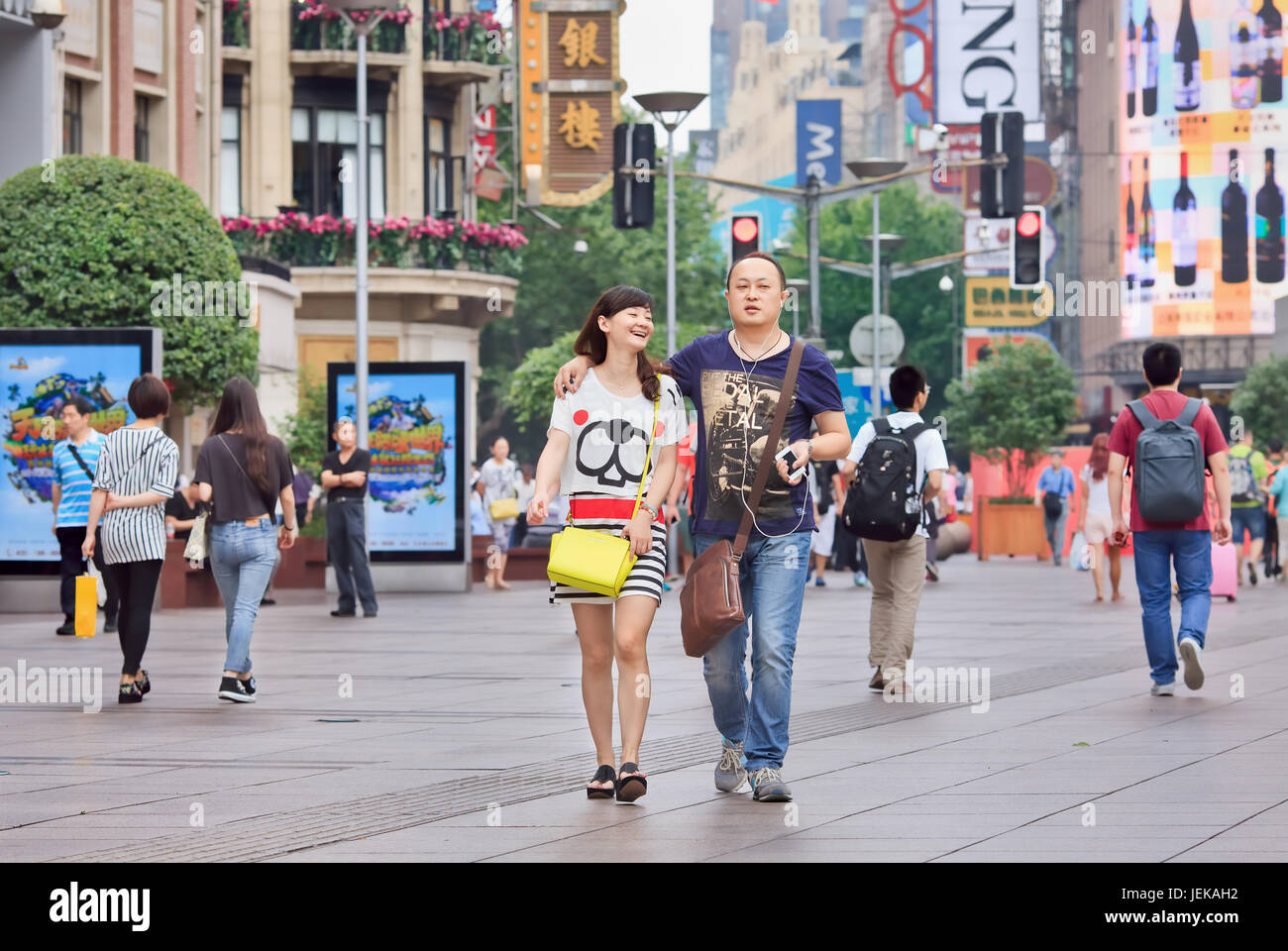 Happy couple at Nanjing Road, Shanghai’s main shopping street. It is one of the world's busiest shopping streets named after Nanjing city. Stock Photo