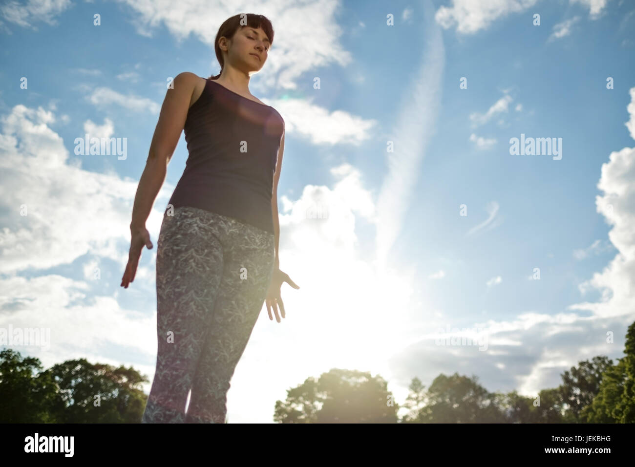 Yoga outdoor in park. Woman doing yoga exercises.Mountain yoga pose tadasana. Stock Photo