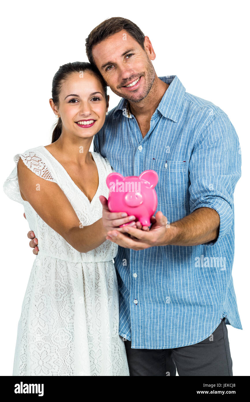 Smiling couple holding piggybank Stock Photo - Alamy