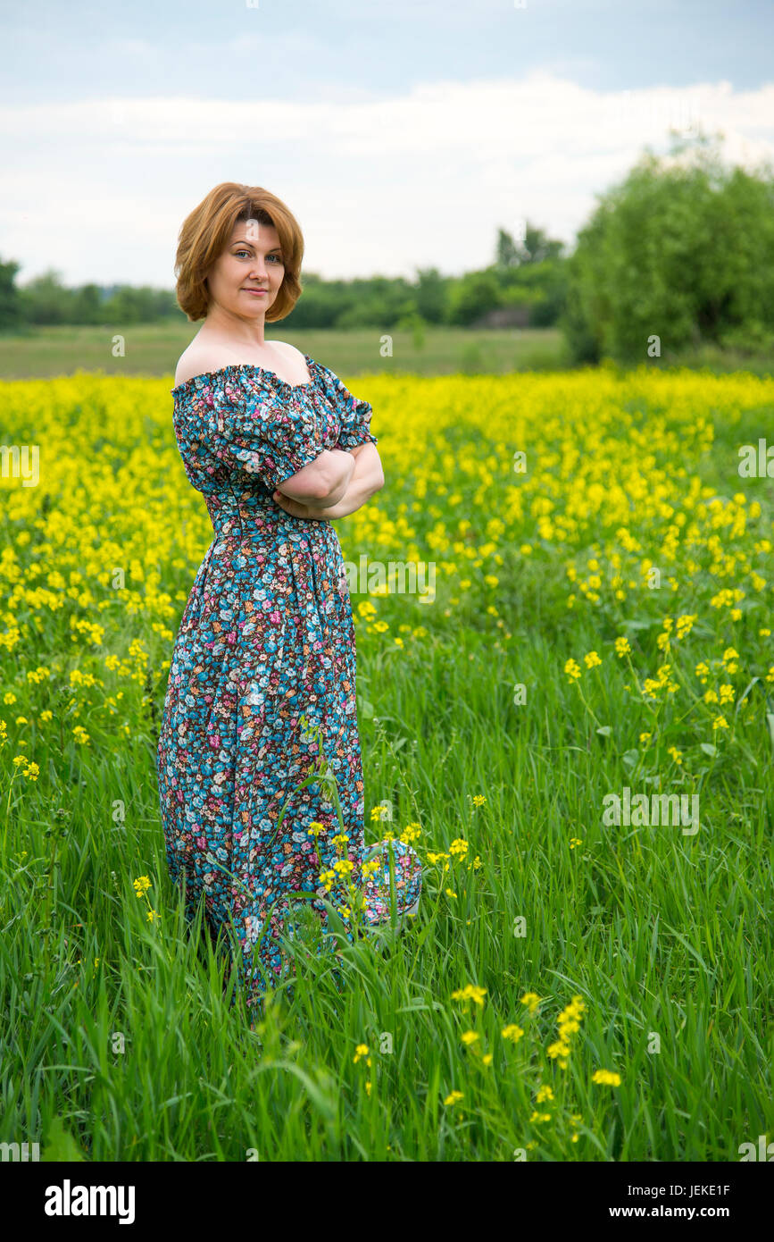 Middle-aged woman standing on summer meadow Stock Photo