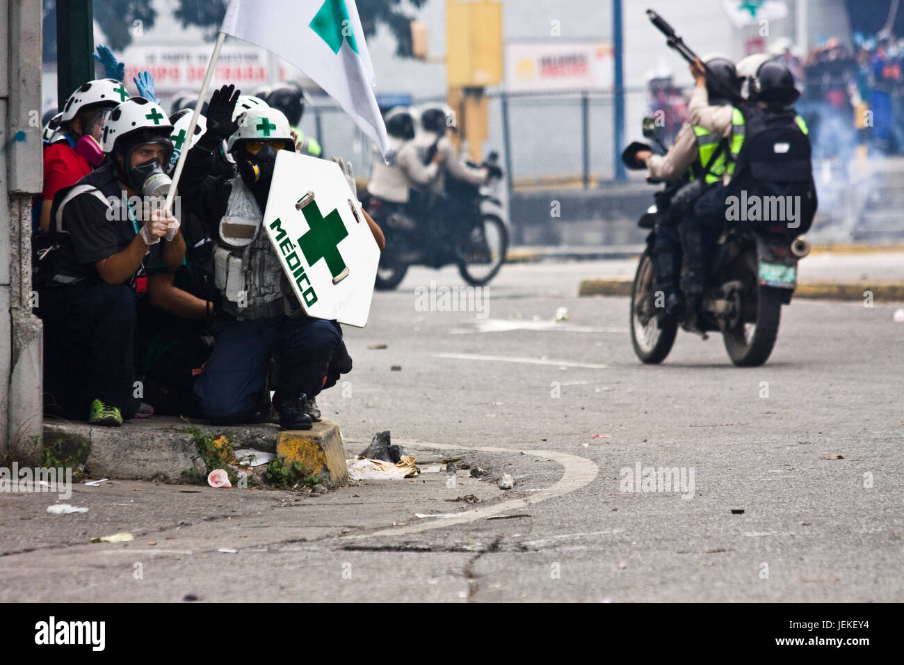 A group of volunteers paramedics hold their hands on the air while the Bolivarian National Police pass at their side. Stock Photo