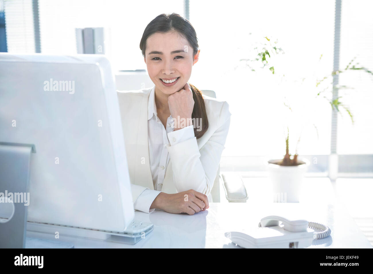 Smiling businesswoman working at her desk Stock Photo - Alamy