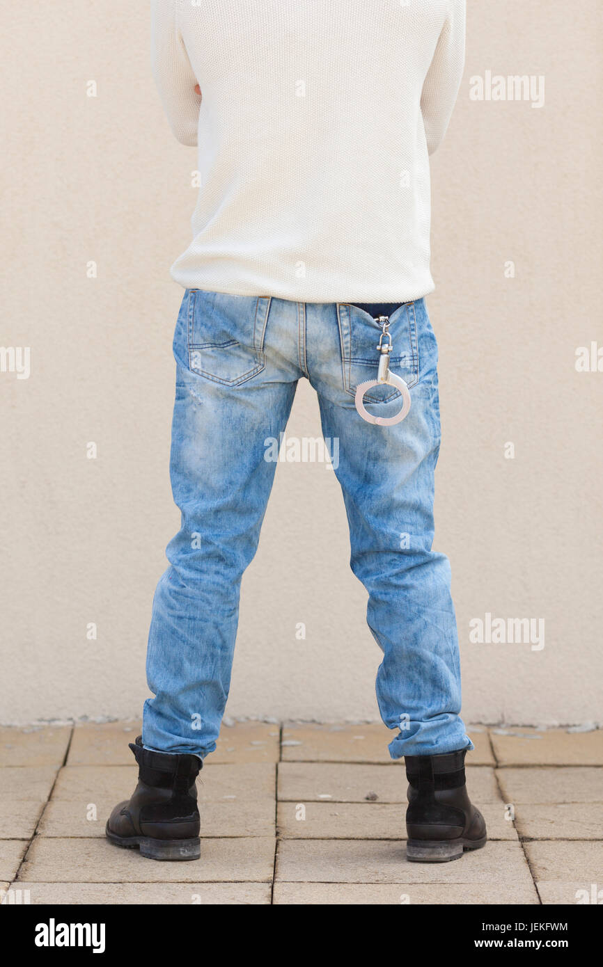 Rear view of a man with handcuffs in his pocket Stock Photo