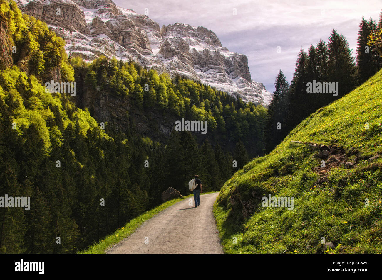 Man walking along mountain road, Seealpsee, Appenzell Innerrhoden, Switzerland Stock Photo
