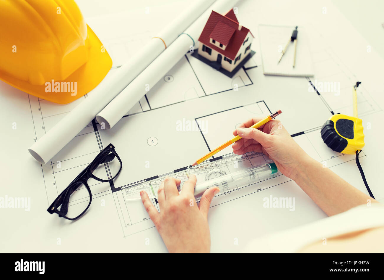 close up of hands with ruler measuring blueprint Stock Photo Alamy
