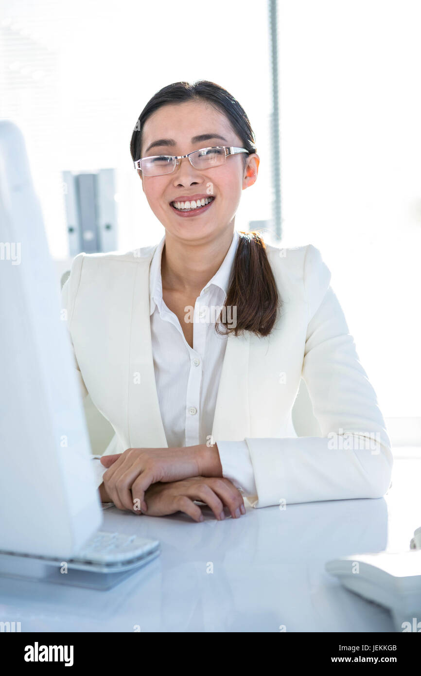 Smiling businesswoman working at her desk Stock Photo - Alamy