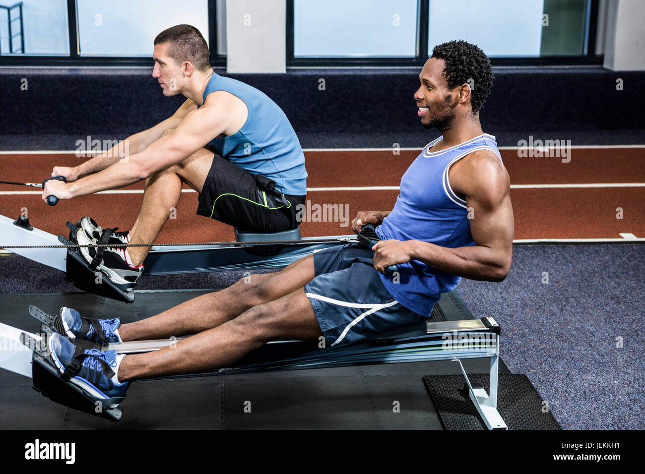 Muscular men using rowing machine Stock Photo