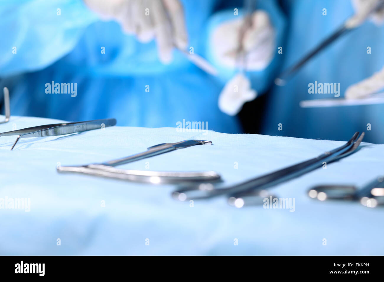 Surgical tools lying on the table while group of surgeons at background