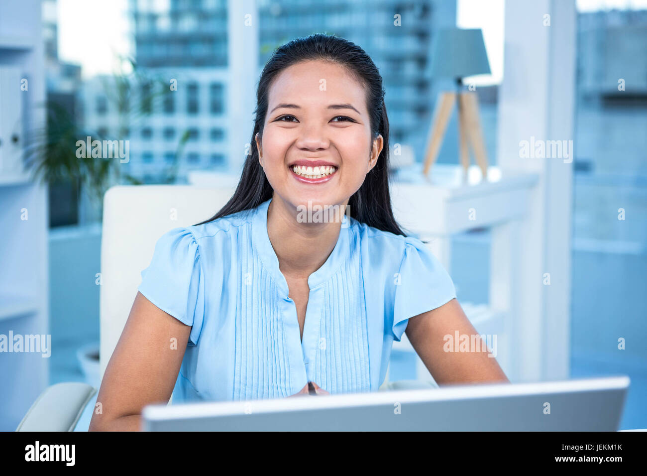 Smiling businesswoman working at her desk Stock Photo - Alamy