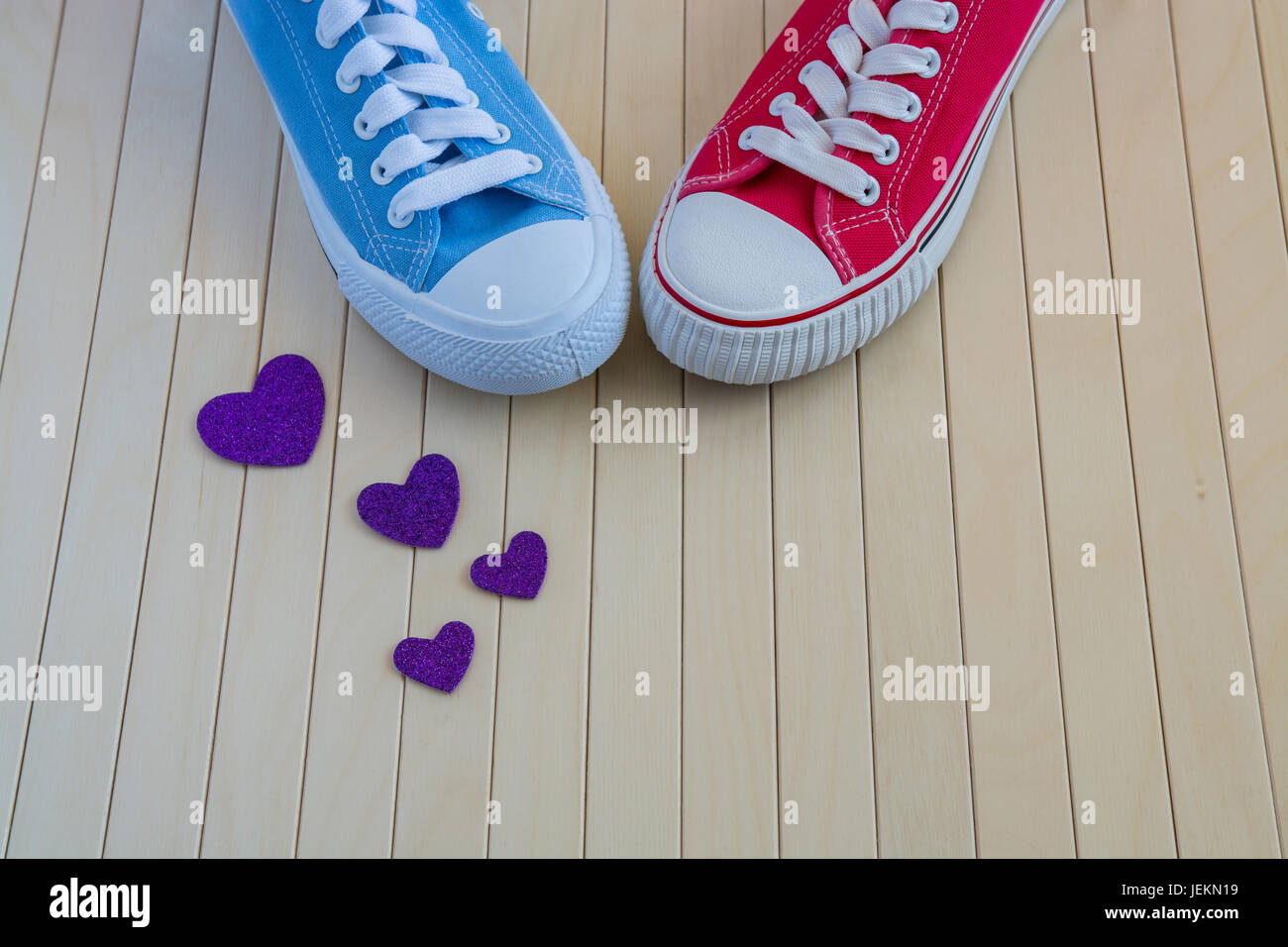 Blue and red sneakers with purple hearts on the wooden background Stock Photo