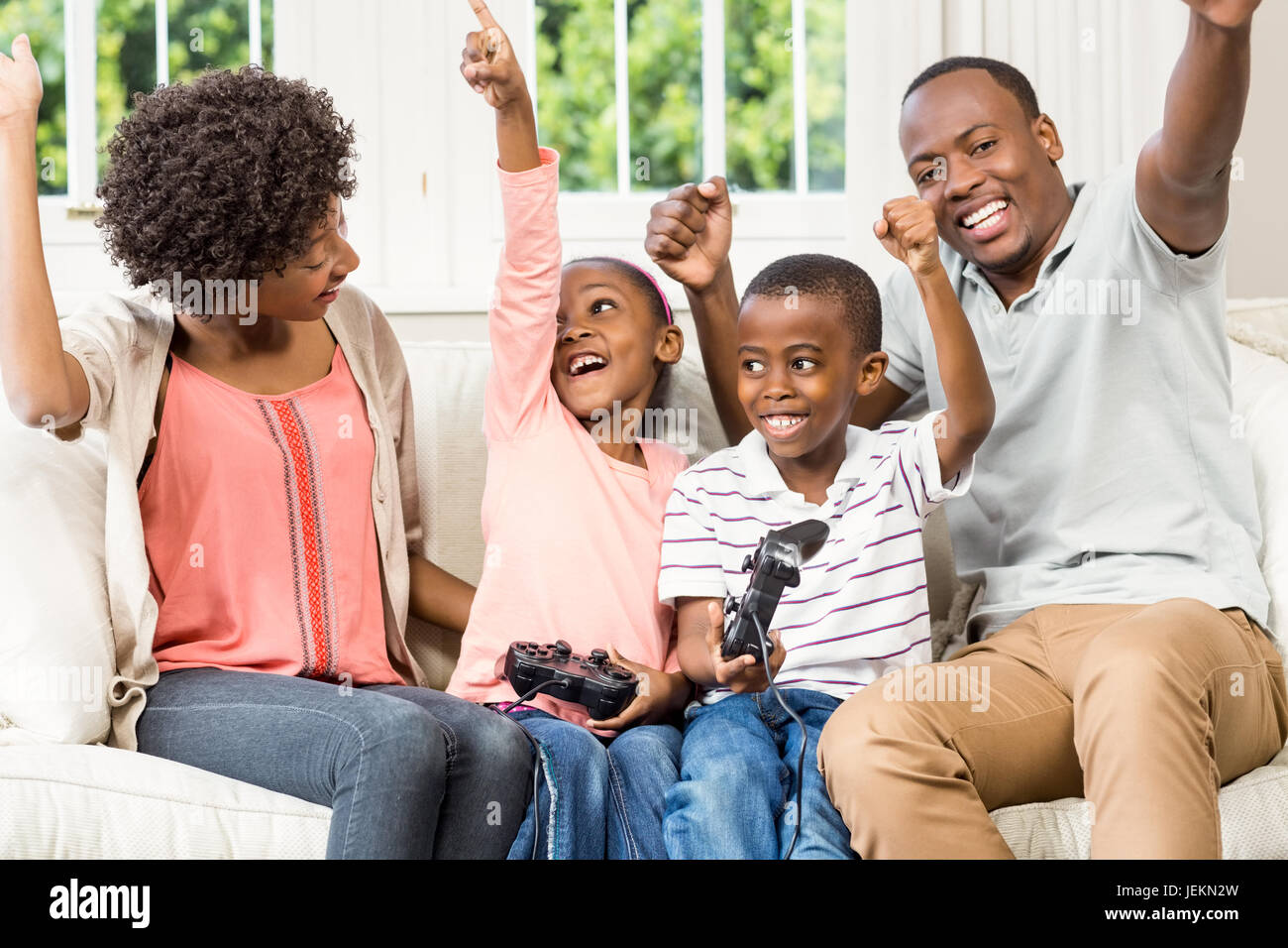 Smiling family sitting on the couch together Stock Photo - Alamy