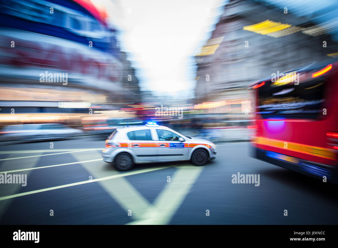 Police Car in Motion - Motion Blur - A London Metropolitan Police Car races across Piccadilly Circus in central London with blue lights flashing Stock Photo