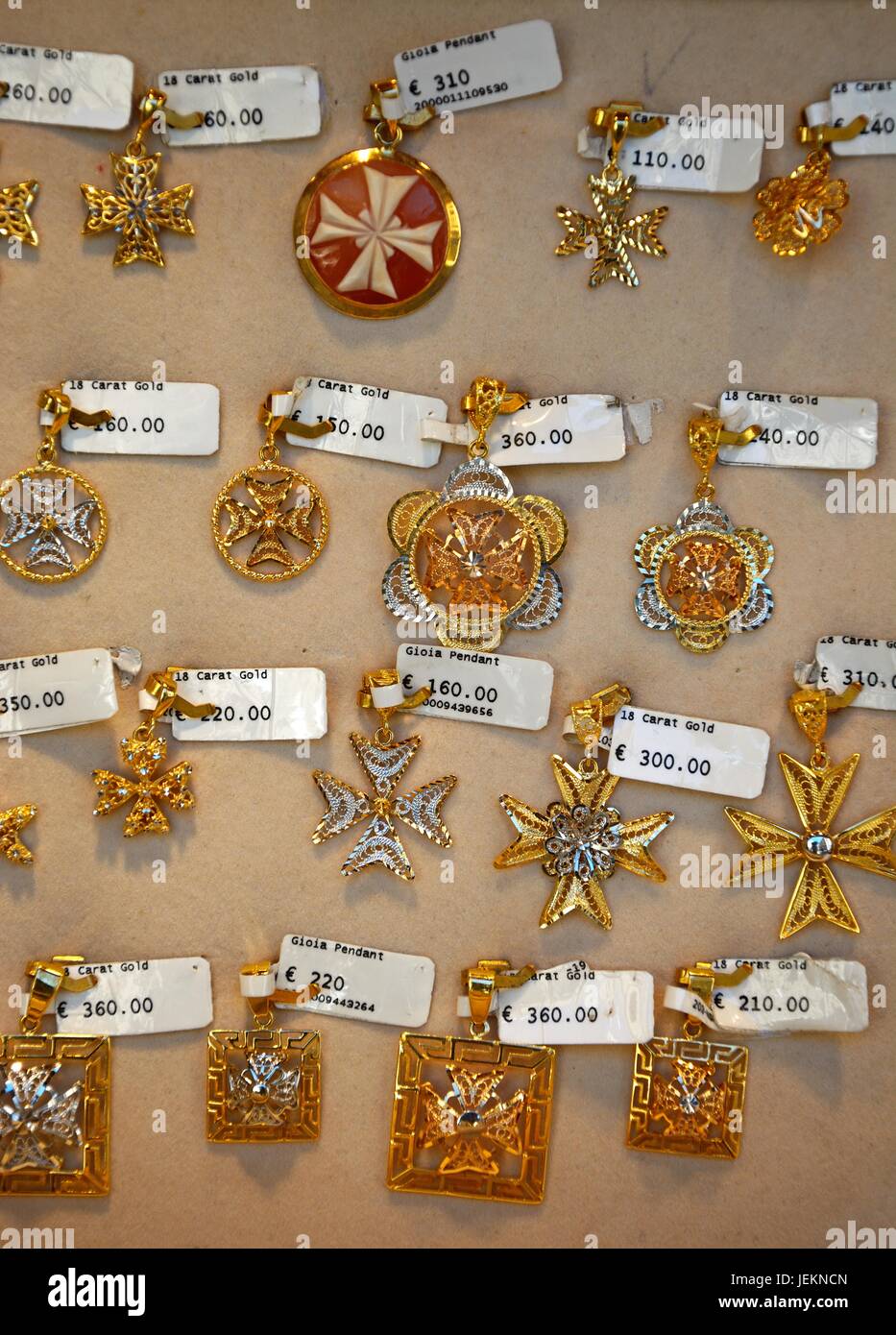 Gold Maltese cross pendants for sale in a shop along Republic Street aka Triq Ir Repubblika, Valletta, Malta, Europe. Stock Photo