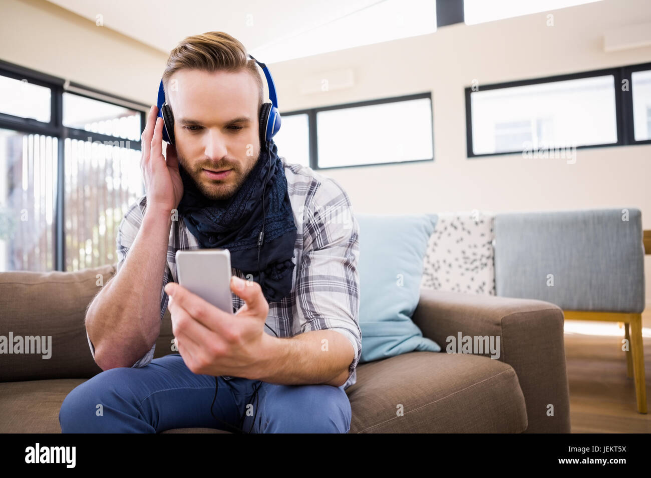 Handsome man listening music on the couch Stock Photo - Alamy