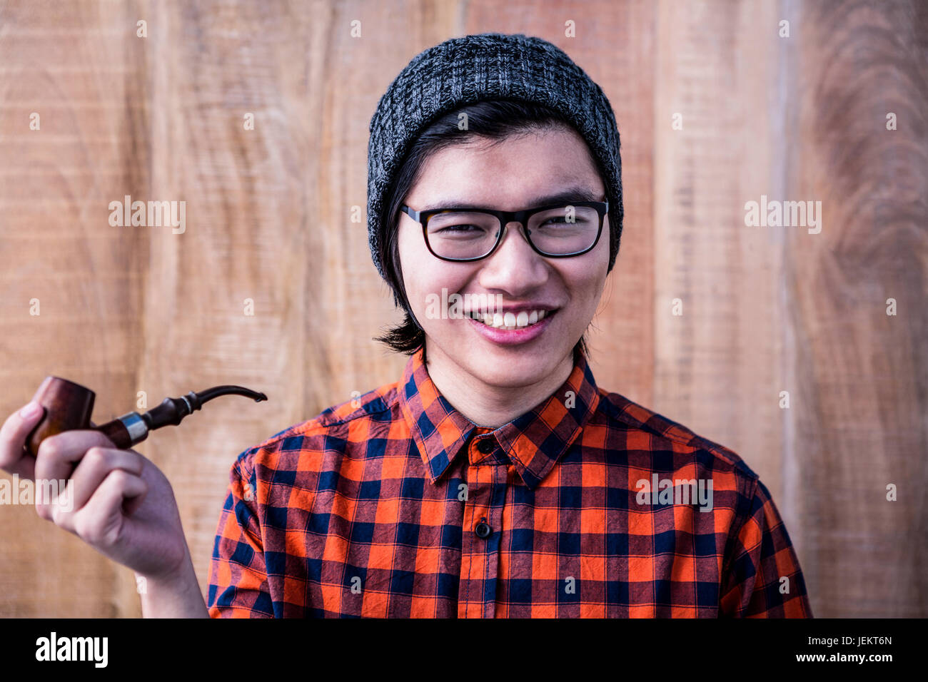 Smiling hipster holding pipe Stock Photo