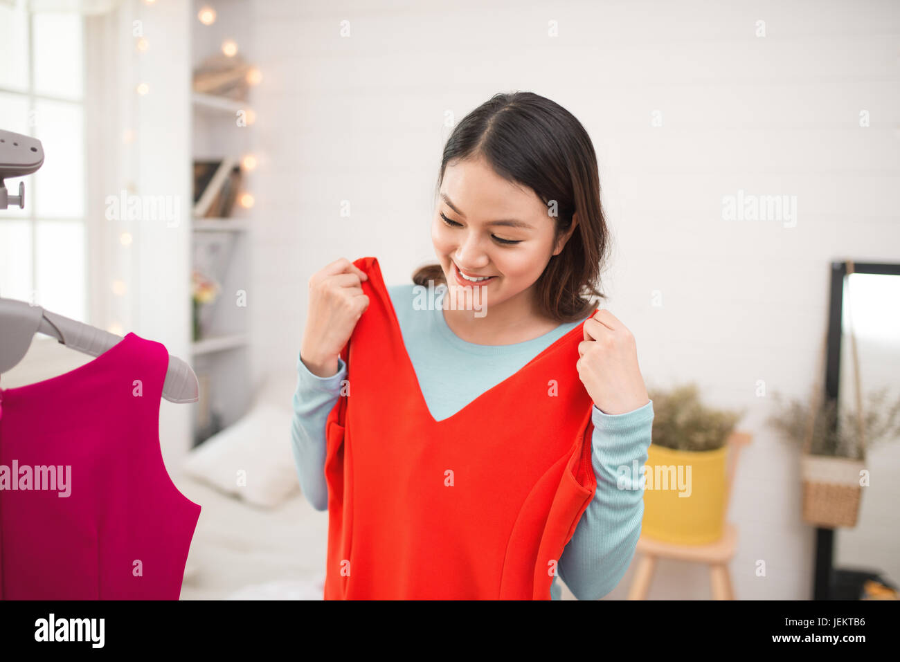 A lovely asian girl trying on new dress at home. Stock Photo
