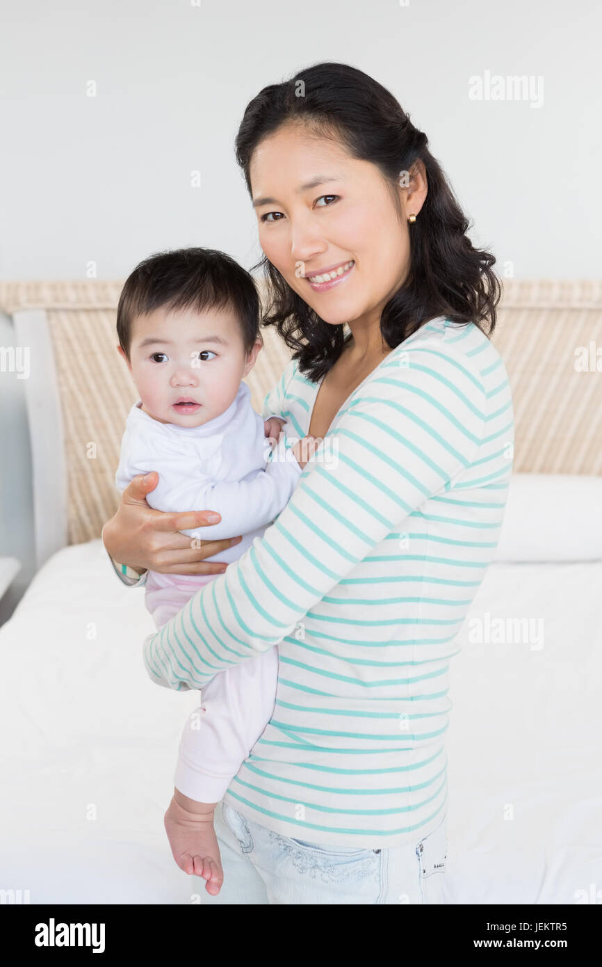 Smiling mother carrying baby daughter Stock Photo - Alamy