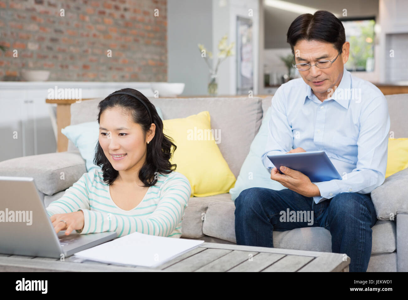 Smiling couple using laptop and tablet Stock Photo - Alamy