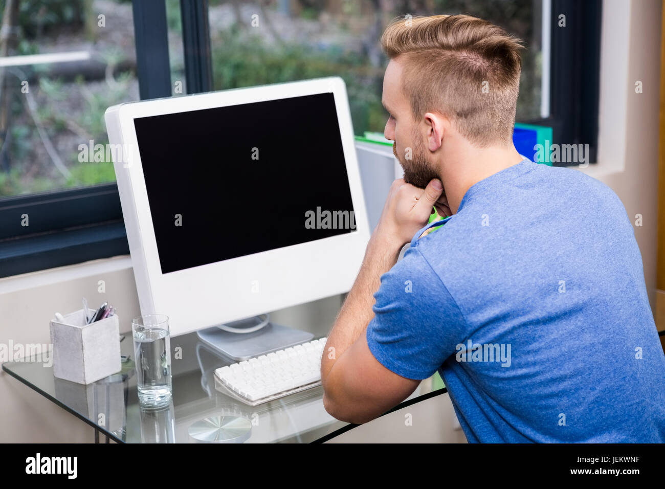 Rear view of man using computer Stock Photo - Alamy
