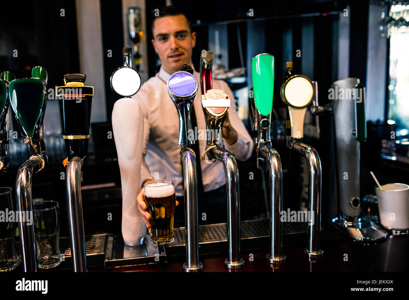 Barman serving a pint of beer Stock Photo