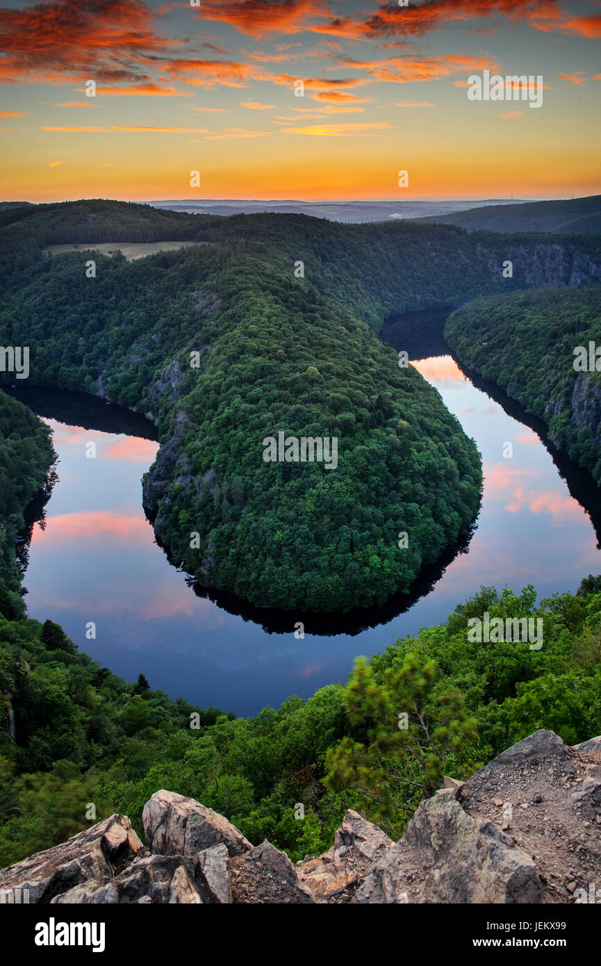 Lookout view form Maj, famous vantage point to Vltava meanders in Czech Republic close to Prague. Orange cloudy sky wit water reflection and natural b Stock Photo