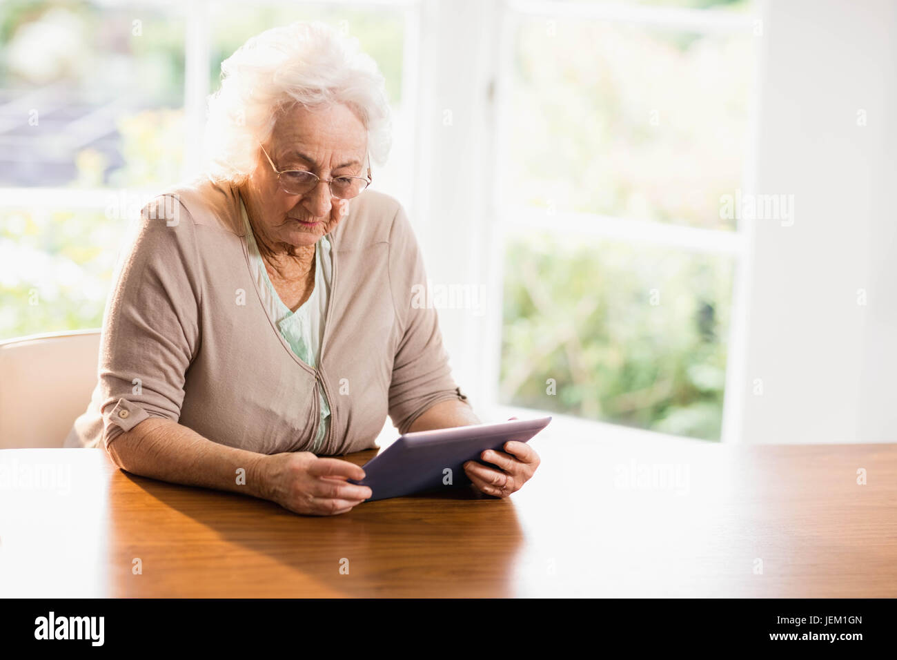 Focused senior woman using tablet Stock Photo