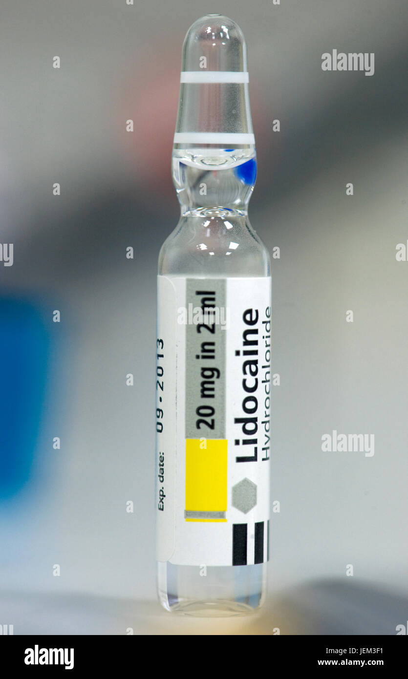 Vial of Lidocaine hydrochloride, a local anaesthetic drug, laid out with other anaesthetics prior to a surgical operation. Stock Photo