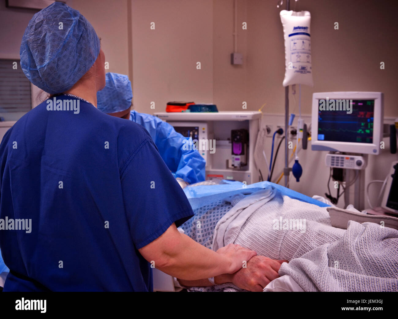 Anaesthetics practitioner nurse keeps a check on a vital signs monitor Stock Photo