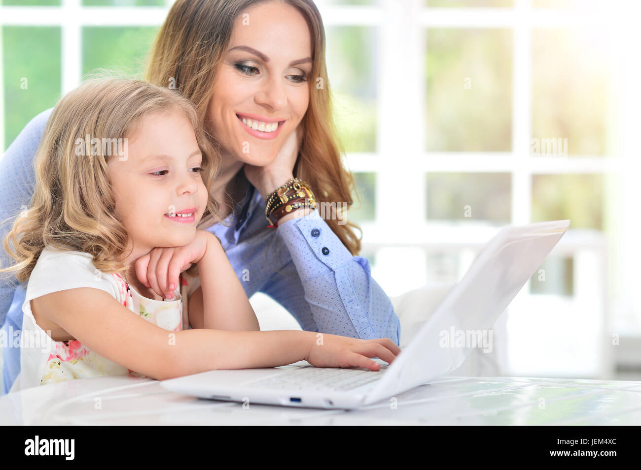 woman and little girl using laptop Stock Photo - Alamy