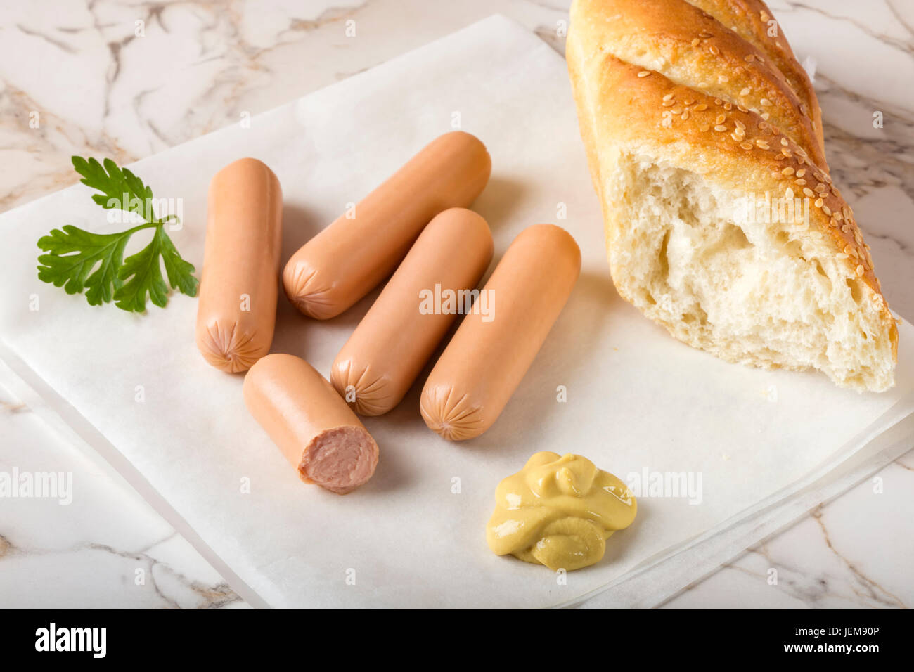 Sausages (Frankfurter) on rustic table with bread and mustard Stock Photo