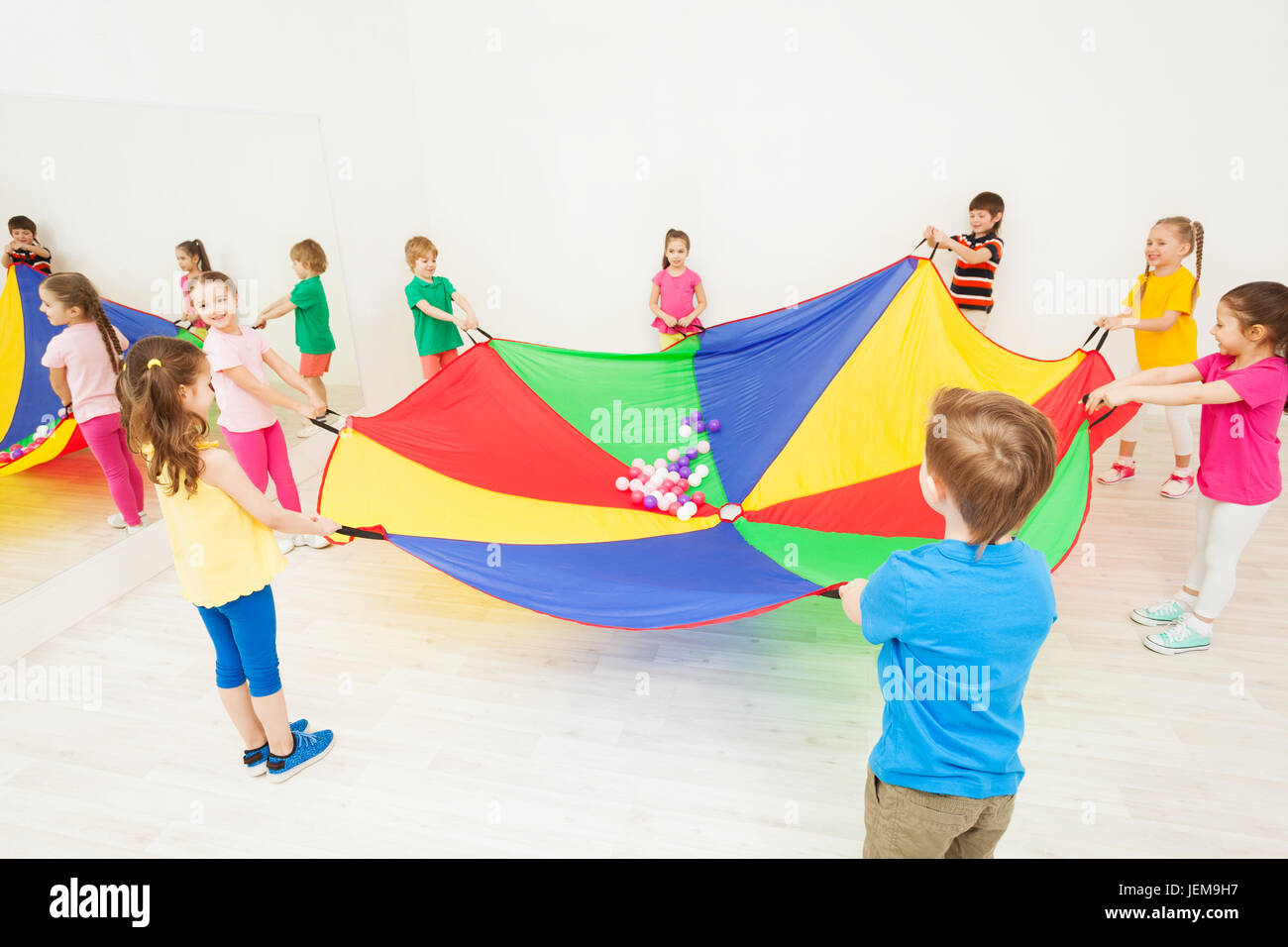 Happy children playing parachute games in gym Stock Photo Alamy