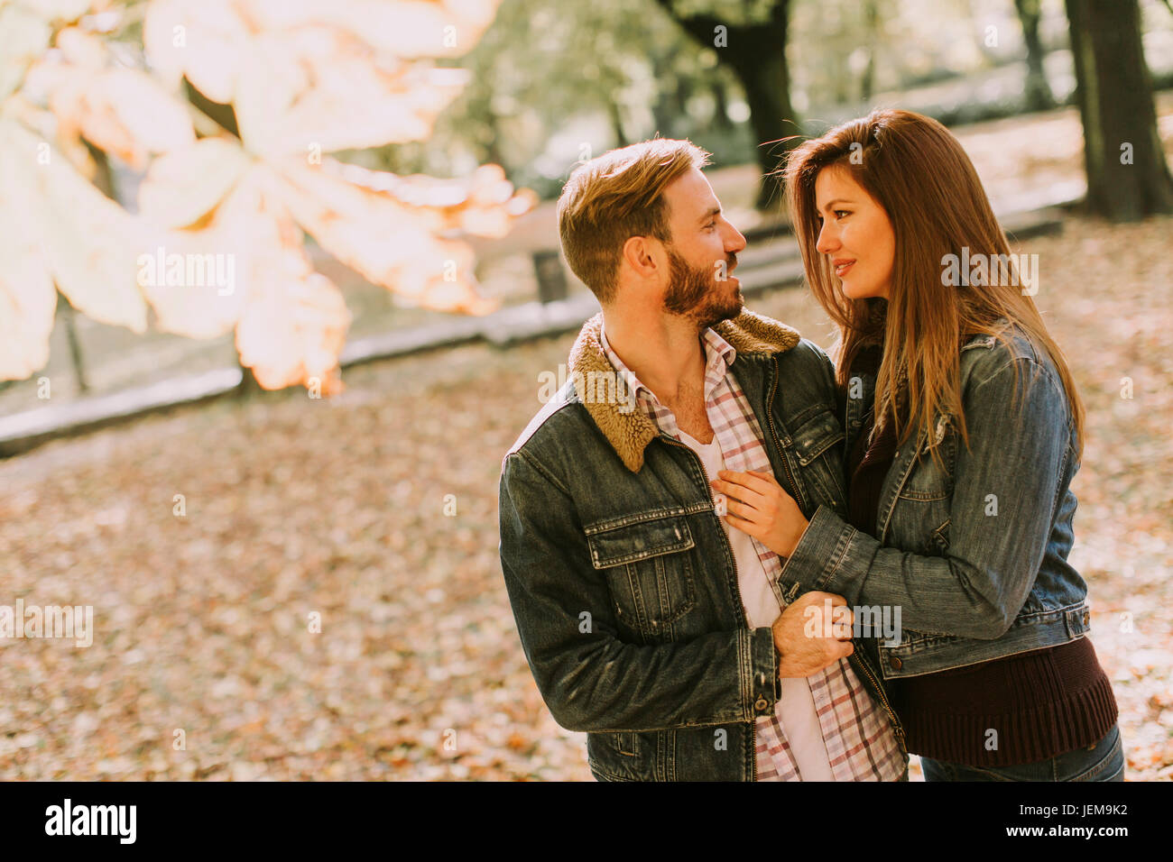 View at smiling couple hugging in autumn park Stock Photo - Alamy