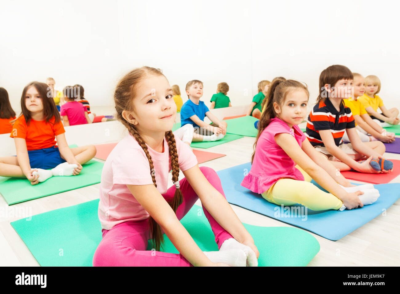 Girl doing butterfly stretch in gymnastic group Stock Photo