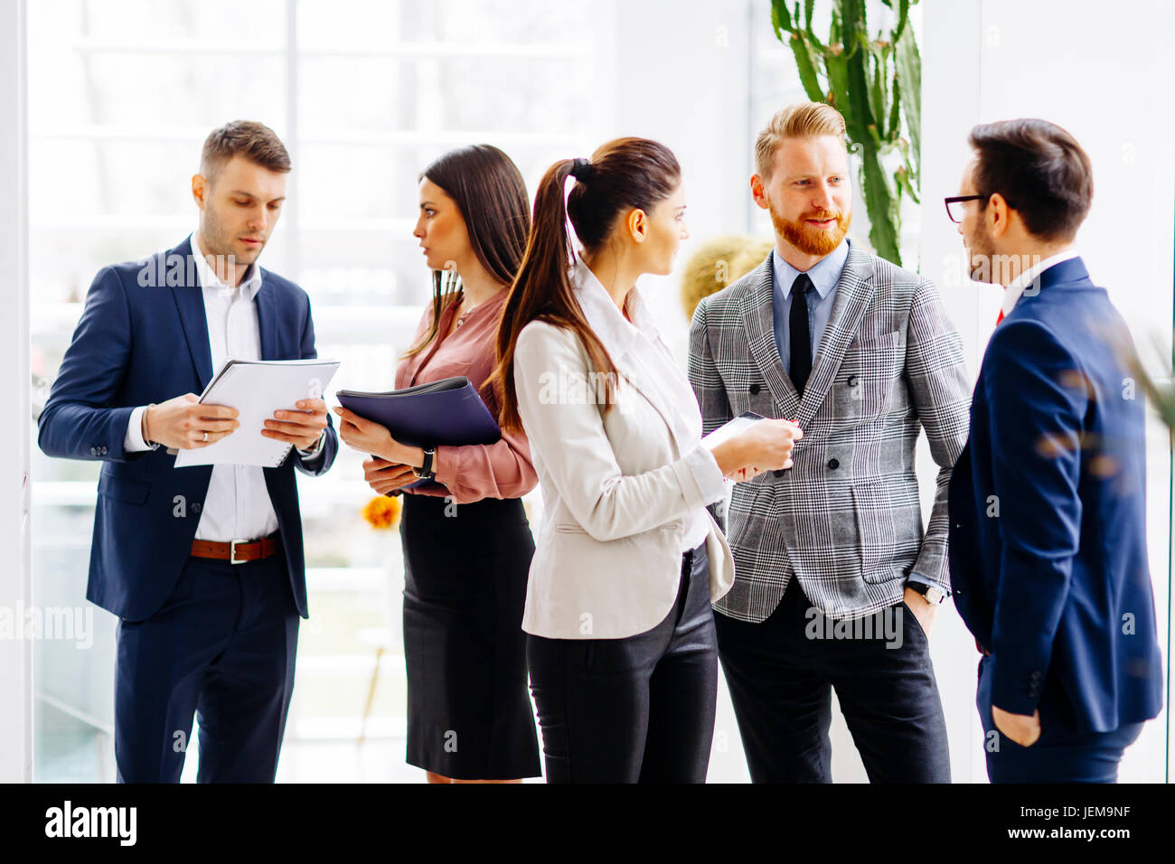 Group of businesspeople standing in the modern office Stock Photo - Alamy