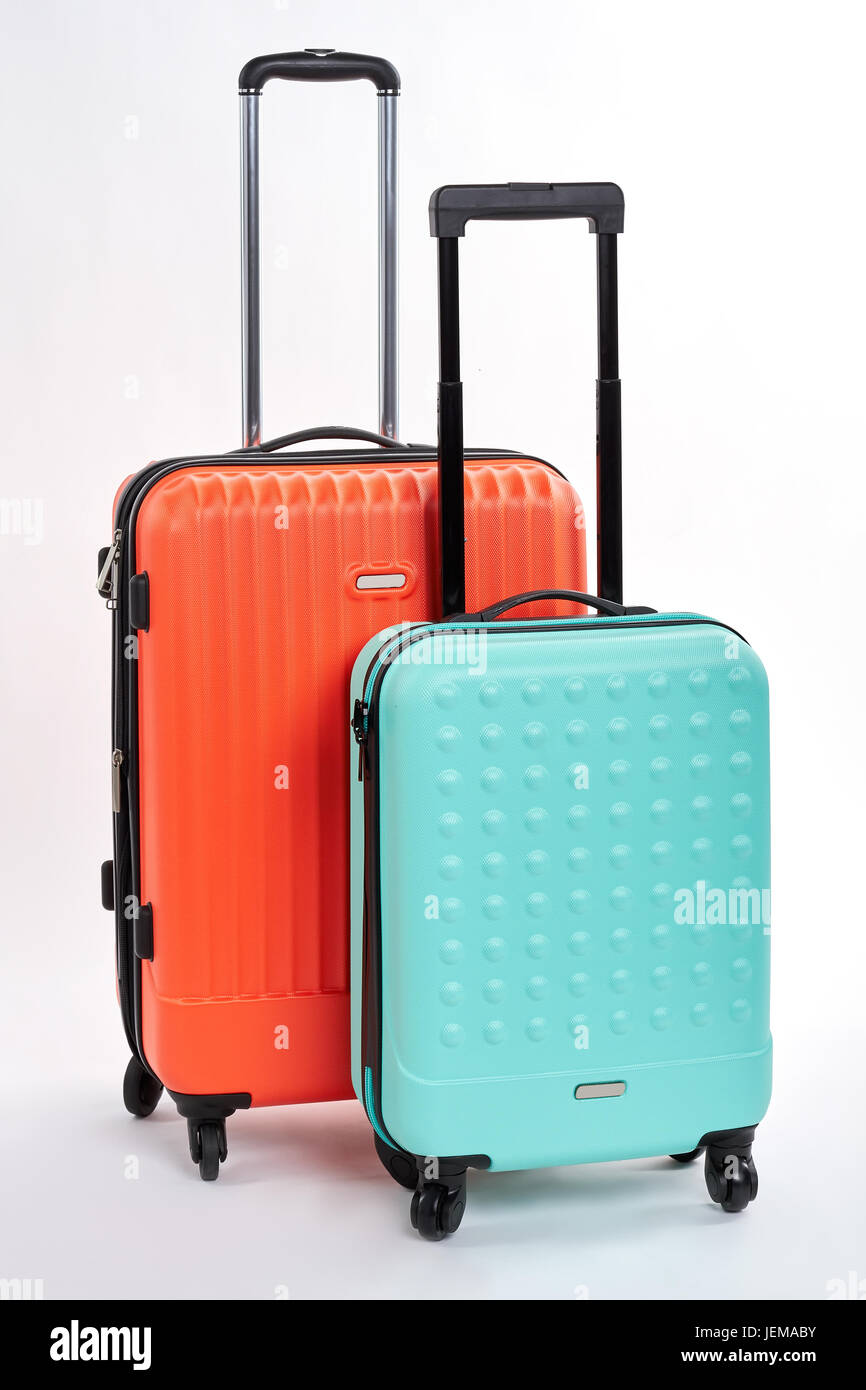 Suitcases with handles close up. Bright wheeled bags for summer holiday